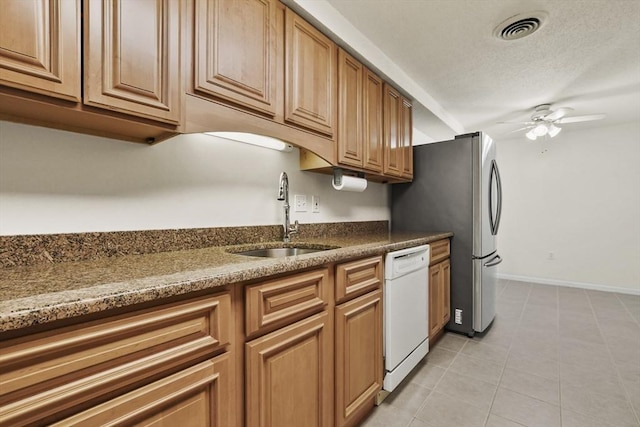 kitchen featuring visible vents, baseboards, dishwasher, a ceiling fan, and a sink