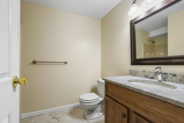 bathroom featuring toilet, tile patterned floors, vanity, and baseboards