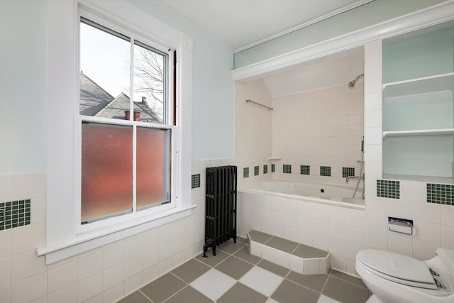 bathroom featuring radiator, tile flooring, tile walls, and toilet