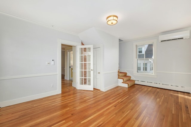 spare room with crown molding, light hardwood / wood-style floors, a wall mounted air conditioner, and baseboard heating