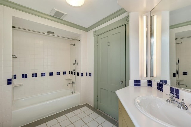 bathroom with tile walls, oversized vanity, tile floors, and tiled shower / bath