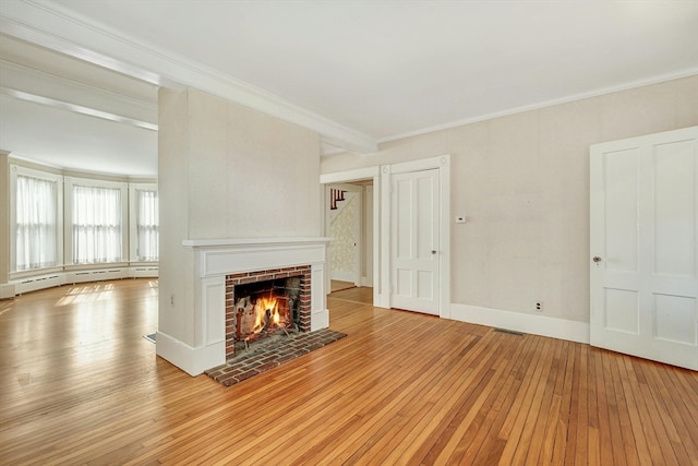 unfurnished living room featuring ornamental molding, baseboard heating, light hardwood / wood-style floors, and a brick fireplace