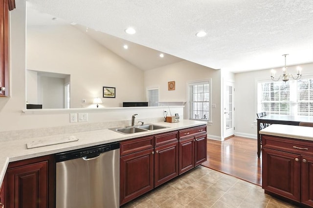 kitchen with stainless steel dishwasher, lofted ceiling, reddish brown cabinets, and a sink