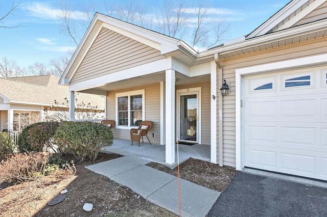 view of exterior entry with covered porch and an attached garage