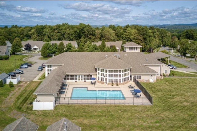 rear view of property with a yard, a fenced in pool, a patio, and fence