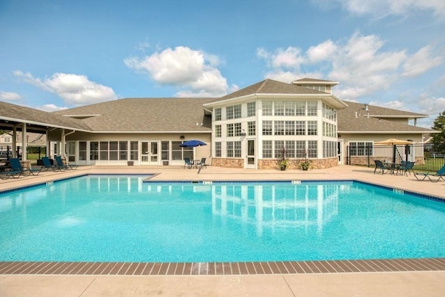 community pool featuring a patio and fence