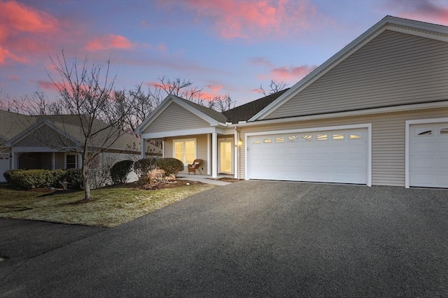 view of front of home with aphalt driveway and a garage