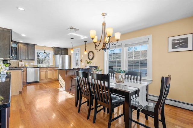 dining area featuring a notable chandelier and light wood-type flooring