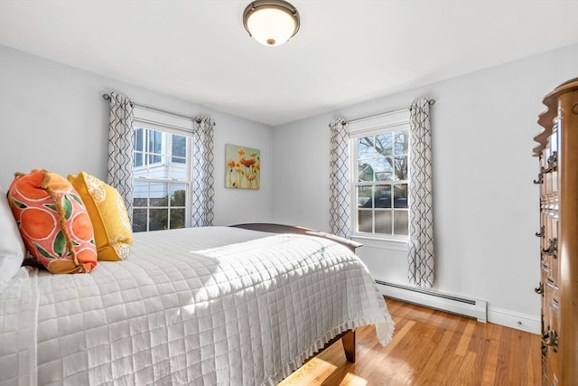 bedroom featuring a baseboard radiator and wood-type flooring