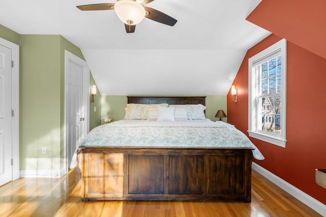 bedroom featuring lofted ceiling, light hardwood / wood-style flooring, and ceiling fan