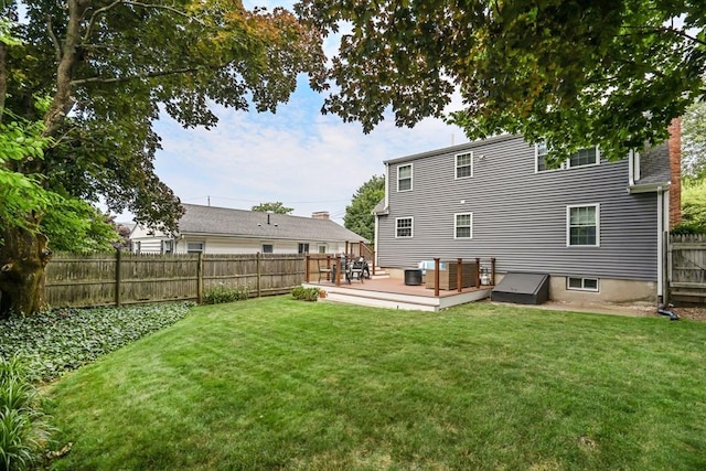 rear view of house featuring a wooden deck and a lawn