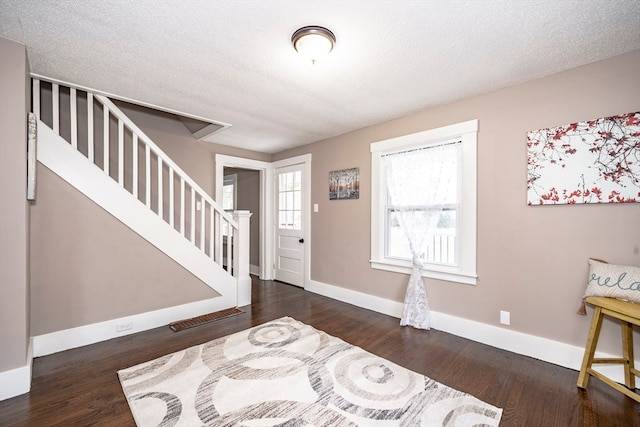 entryway with dark hardwood / wood-style floors and a textured ceiling