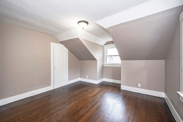 bonus room featuring a textured ceiling, vaulted ceiling, and dark hardwood / wood-style flooring