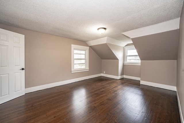 bonus room featuring vaulted ceiling, a textured ceiling, and dark hardwood / wood-style flooring