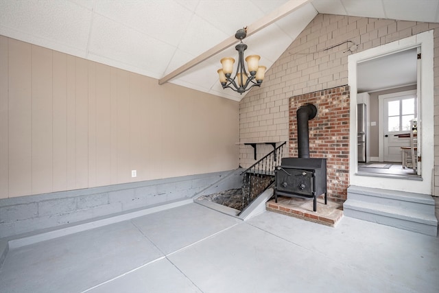 unfurnished living room with a wood stove, concrete flooring, and vaulted ceiling