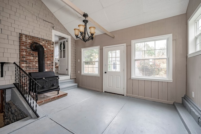 foyer featuring concrete floors, vaulted ceiling, and a wealth of natural light