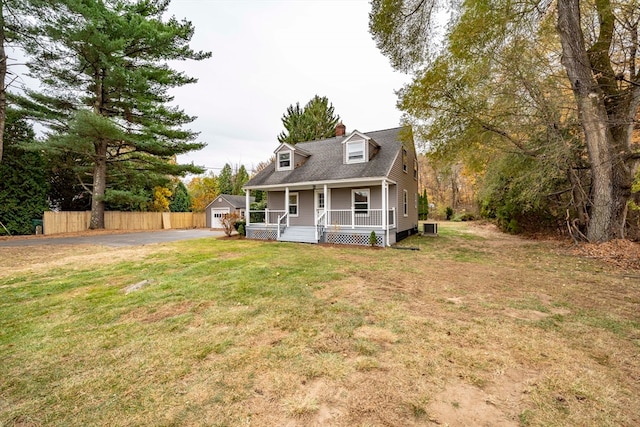 cape cod house featuring a porch, a front yard, central air condition unit, and a garage