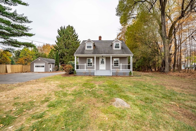 cape cod-style house with a porch, a front yard, an outbuilding, and a garage