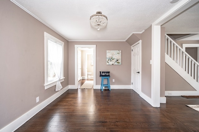 interior space with crown molding, a textured ceiling, dark hardwood / wood-style flooring, and an inviting chandelier