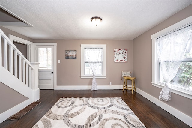 foyer featuring dark wood-type flooring and a textured ceiling