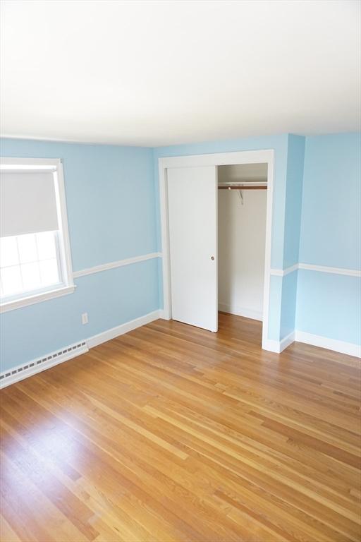 40 Miriam Ln, Lowell, MA 01852 - unfurnished bedroom with baseboard heating, light wood-style flooring, and a closet