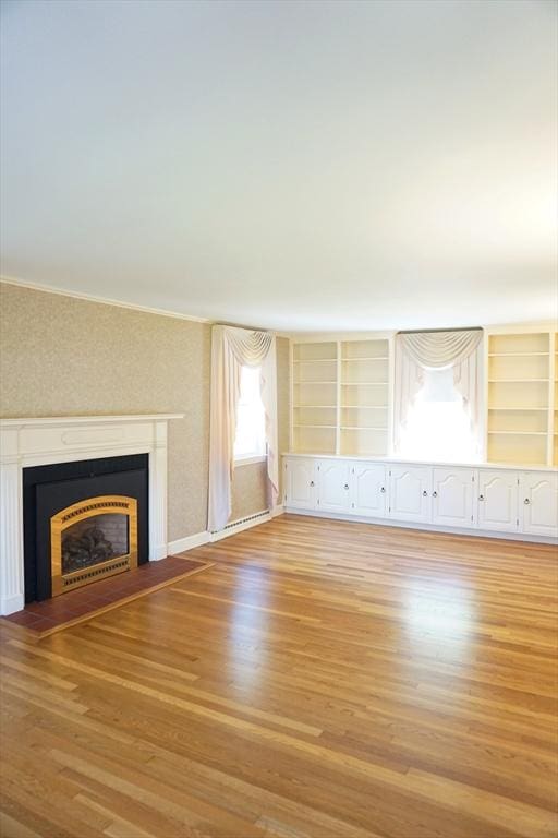40 Miriam Ln, Lowell, MA 01852 - unfurnished living room featuring light wood finished floors, a fireplace with flush hearth, crown molding, and baseboard heating