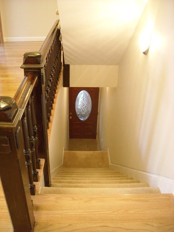 stairway with wood-type flooring and vaulted ceiling