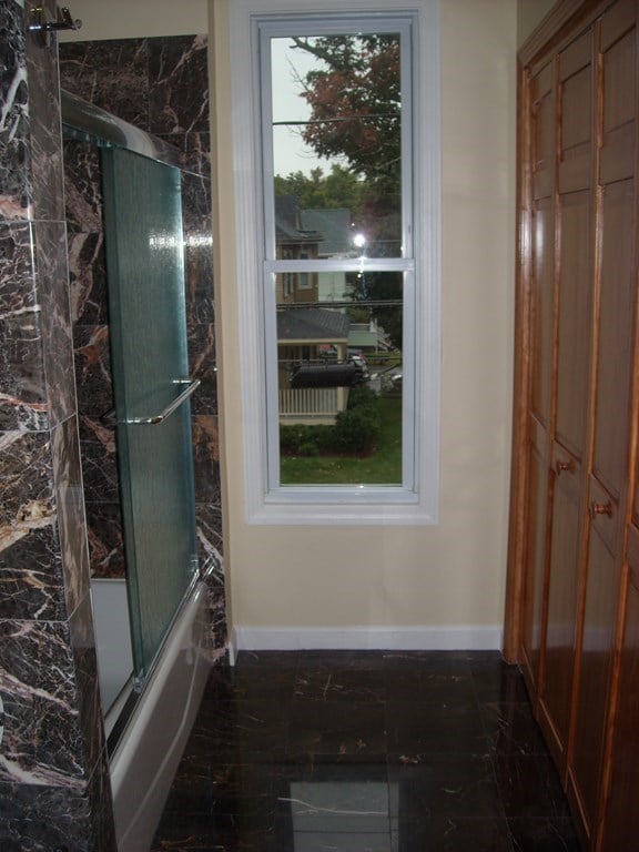 bathroom with bath / shower combo with glass door