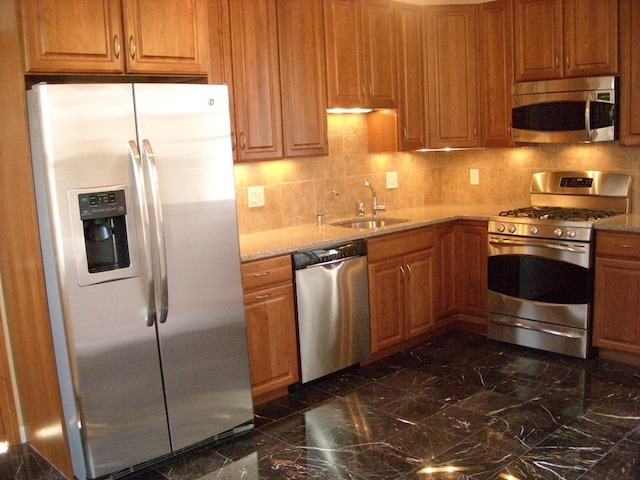 kitchen featuring backsplash, appliances with stainless steel finishes, and sink