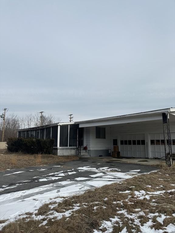 view of front facade featuring a garage, a sunroom, and a carport