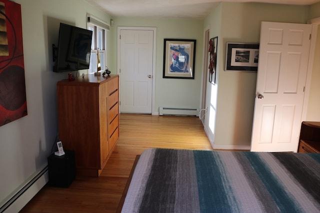 corridor featuring light wood-type flooring and a baseboard heating unit