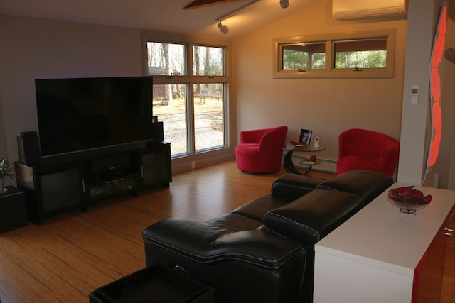 living room featuring a wall unit AC, vaulted ceiling, and hardwood / wood-style flooring