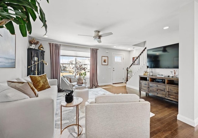 living area with dark wood-type flooring, ceiling fan, baseboards, stairs, and recessed lighting