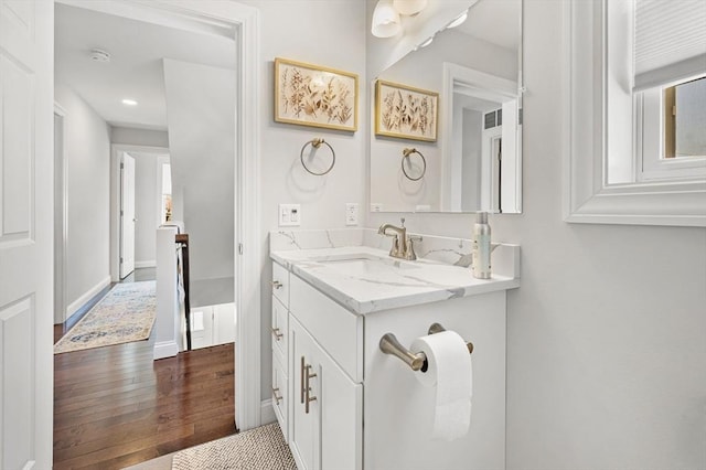 bathroom with vanity, baseboards, and wood-type flooring