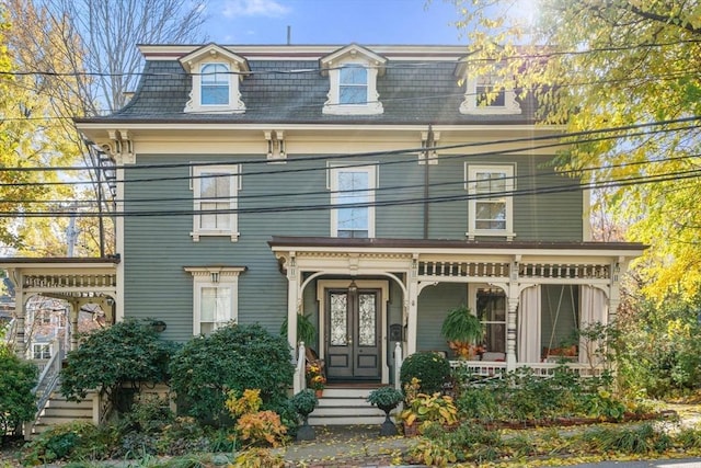 view of front facade with mansard roof, covered porch, and french doors