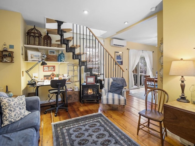 living room with hardwood / wood-style floors and a wall unit AC