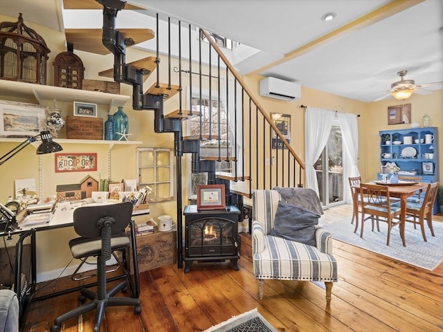 office featuring hardwood / wood-style floors, a wealth of natural light, an AC wall unit, and ceiling fan