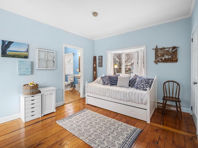 interior space featuring hardwood / wood-style floors, crown molding, and ensuite bath