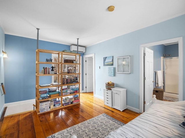 bedroom featuring light hardwood / wood-style flooring and a wall unit AC