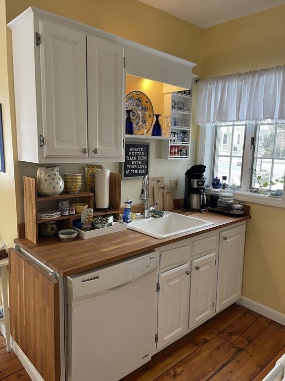 kitchen featuring dark hardwood / wood-style floors, sink, white cabinets, and white dishwasher