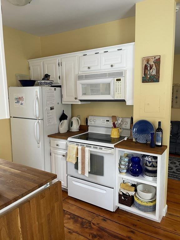 kitchen with white cabinetry, white appliances, and dark hardwood / wood-style flooring