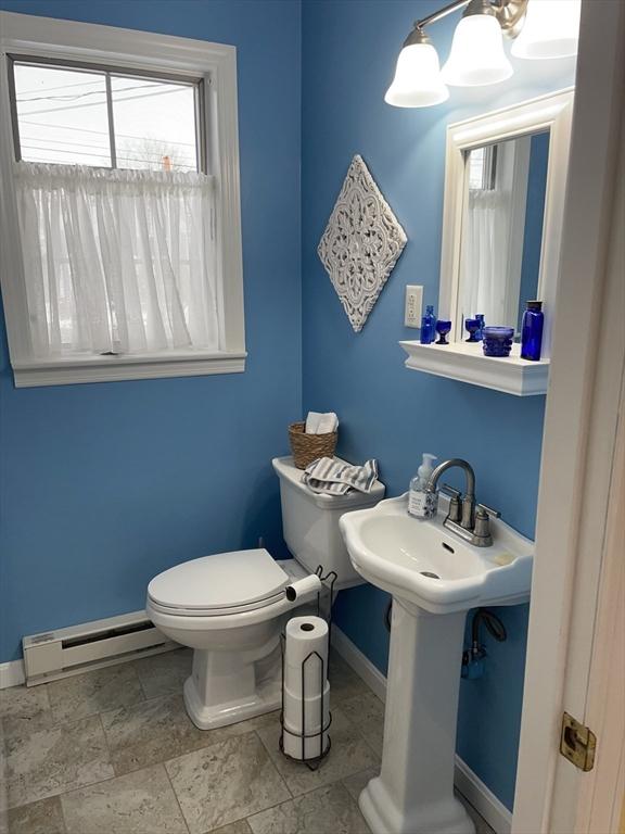 bathroom with a chandelier, toilet, and baseboard heating