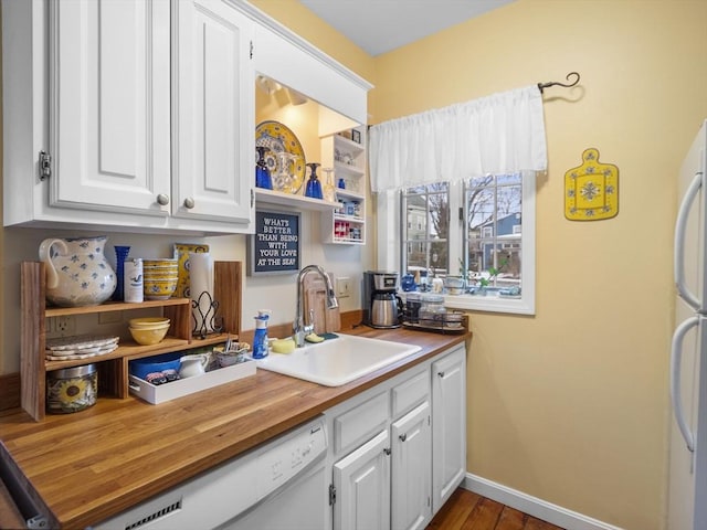 kitchen with butcher block counters, sink, dark hardwood / wood-style floors, white appliances, and white cabinets