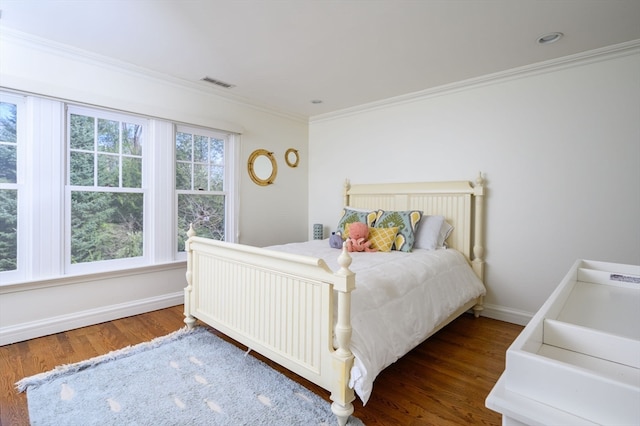 bedroom with ornamental molding and hardwood / wood-style floors