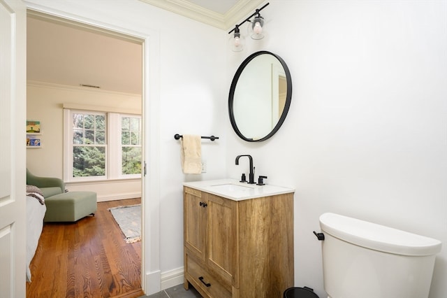 bathroom with toilet, ornamental molding, vanity, and hardwood / wood-style floors