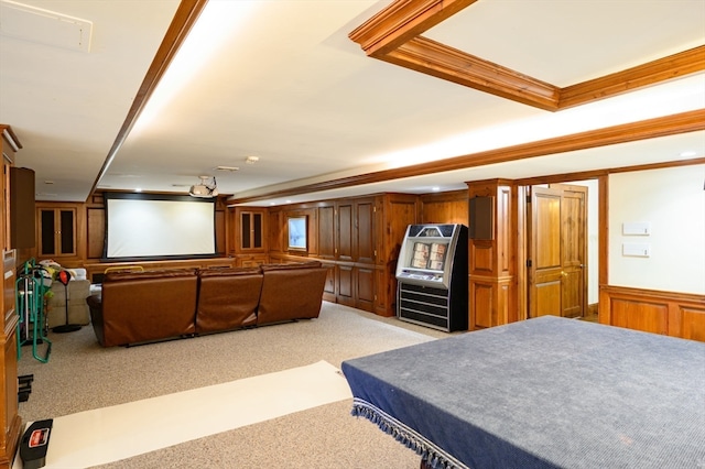 carpeted home theater room featuring crown molding and wood walls