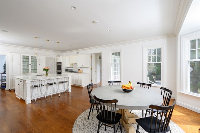 dining space featuring ornamental molding and wood-type flooring