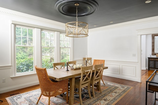 dining space with dark hardwood / wood-style flooring, crown molding, and plenty of natural light