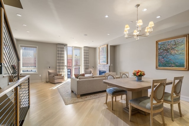 dining area with a notable chandelier and light hardwood / wood-style flooring