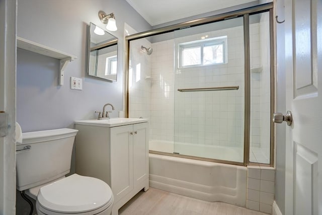 full bathroom with wood-type flooring, vanity, toilet, and bath / shower combo with glass door